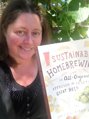 Author Amelia Loftus holding her book Sustainable Home Brewing